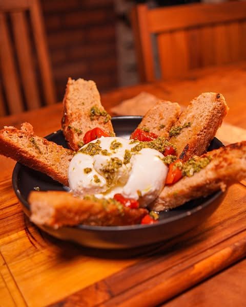 Burrata com tomates e pães tostados
