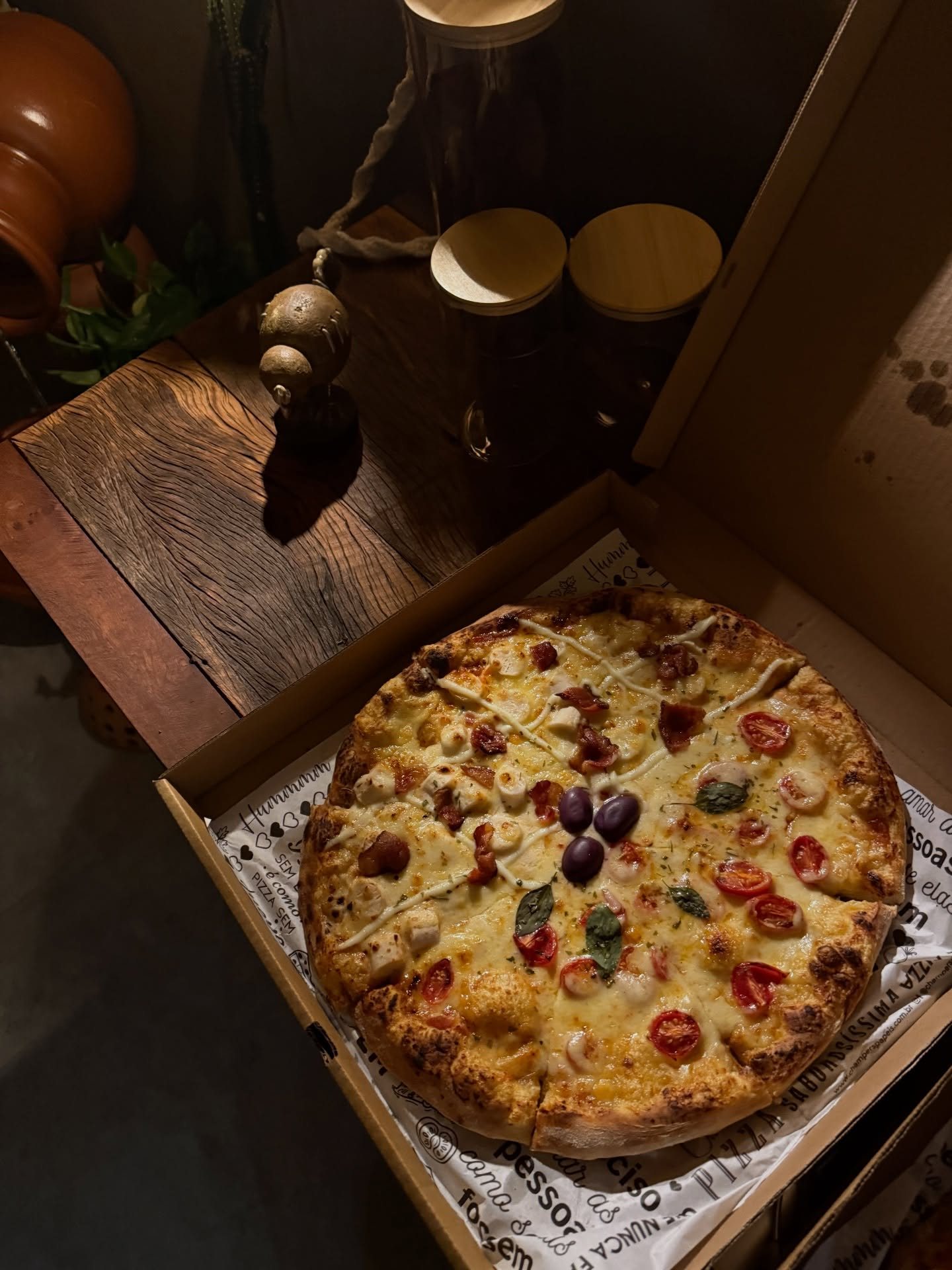 Pizza meio a meio com borda alta e dourada, servida na caixa