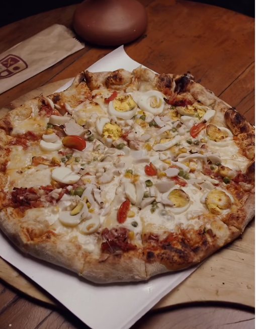 Pizza com ovos, ervilha e tomate